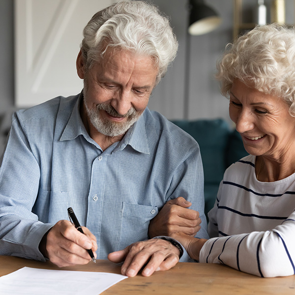 60s elderly spouses at lawyer office sitting at desk hoary husband holding pen family ready sign marriage contract make legal formalities at notary, bequeath savings and property to children concept
