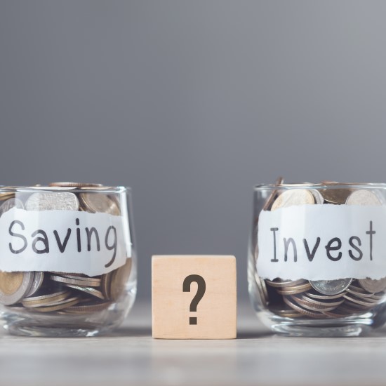 Two pots one labelled saving and one labeled invest, both with cash in